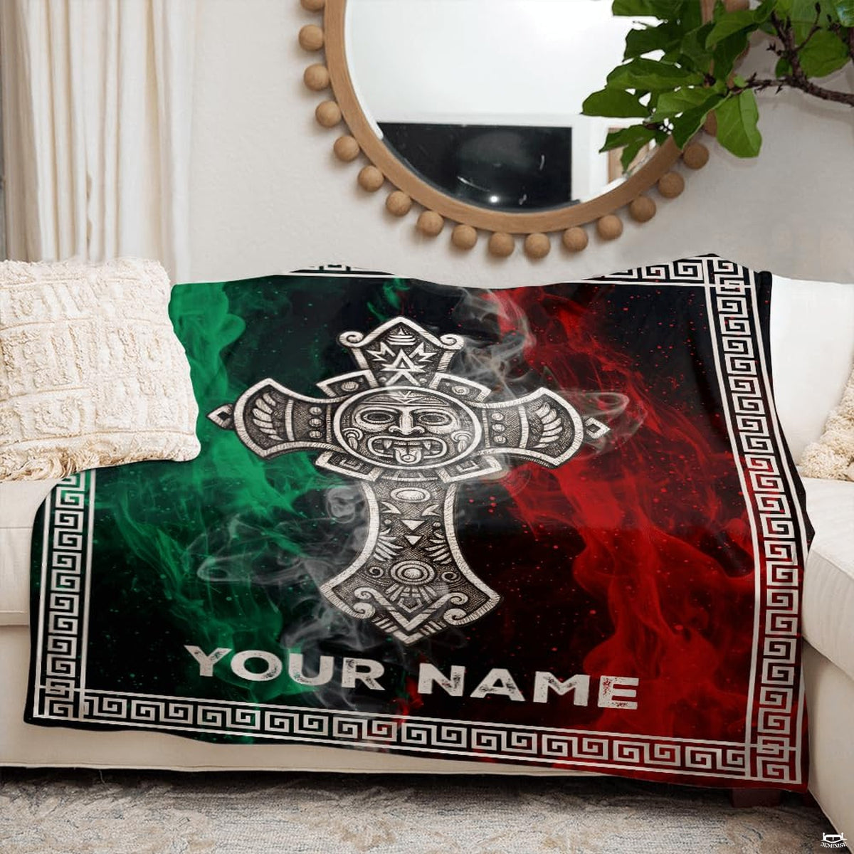 Folded Aztec sun stone cross throw blanket resting on wooden table displaying carved stone artwork