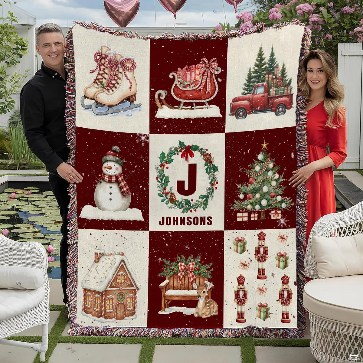 Festive Christmas sampler blanket draped across a sofa beside an illuminated holiday tree