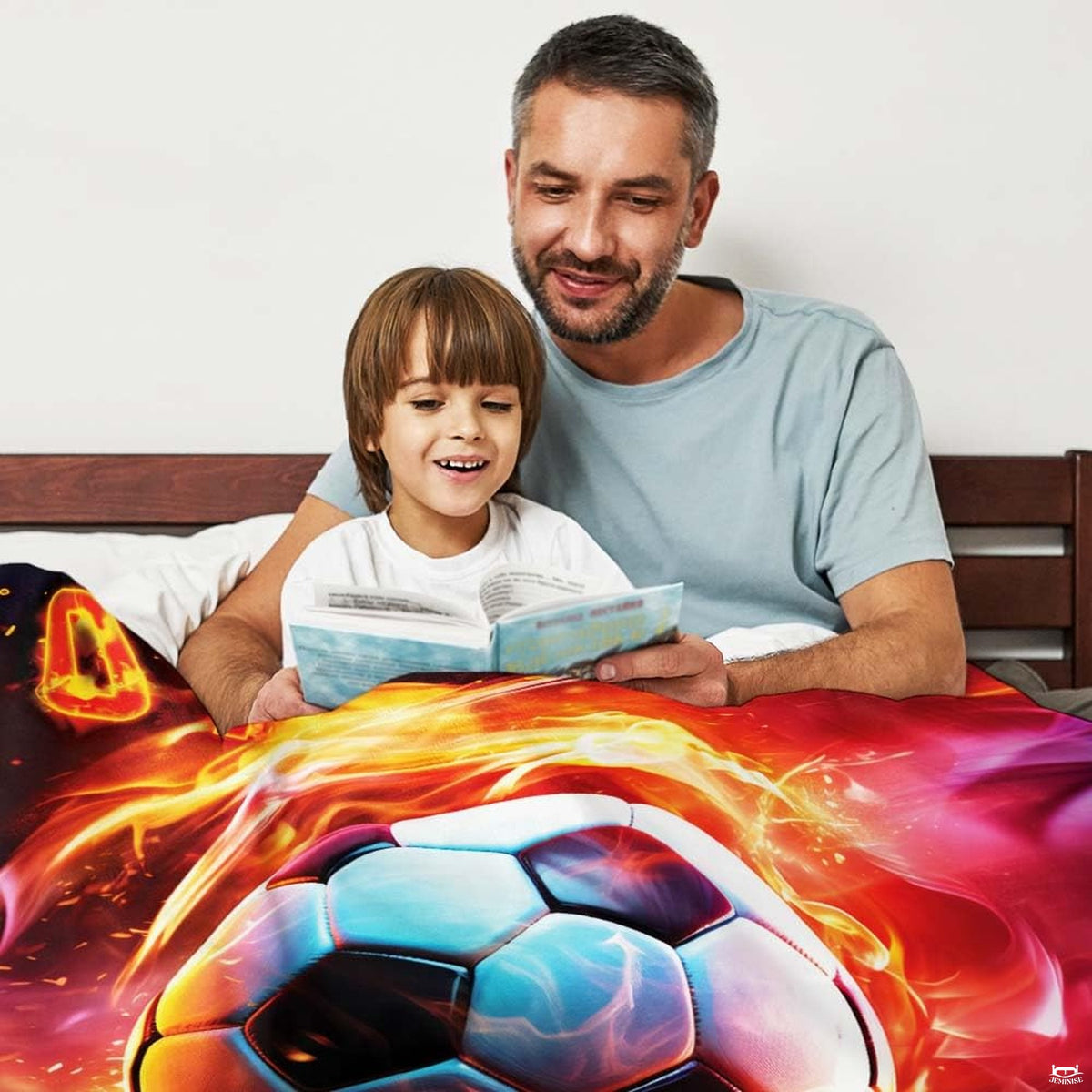 Bed setting with parent and child reading book beneath the swirling soccer fire design.