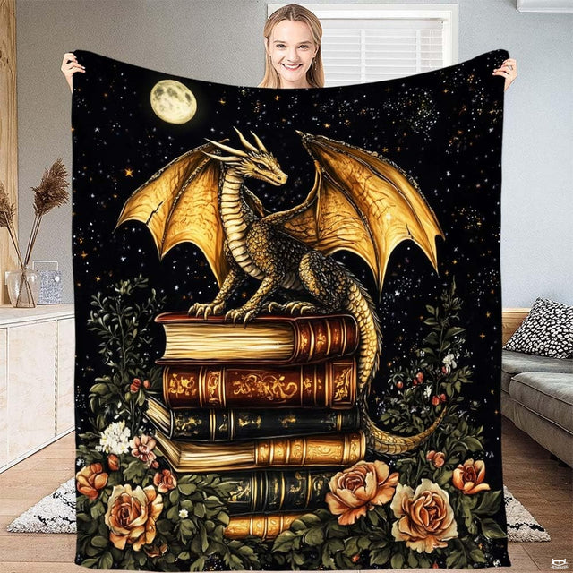 Golden dragon throw blanket showing a winged dragon perched on vintage book stack beneath a full moon.
