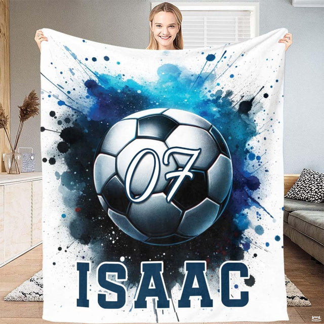 Soccer blanket held up displaying watercolor blue paint splatter soccer ball design