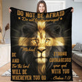 Person standing indoors holding up a devotional lion portrait and golden cross throw blanket.