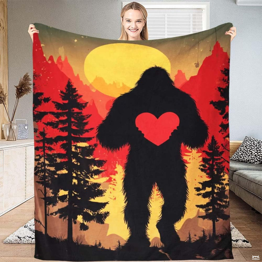 Bigfoot holding heart sunset throw blanket featuring a Sasquatch carrying a red heart before a yellow full moon