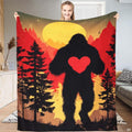Bigfoot holding heart sunset throw blanket featuring a Sasquatch carrying a red heart before a yellow full moon
