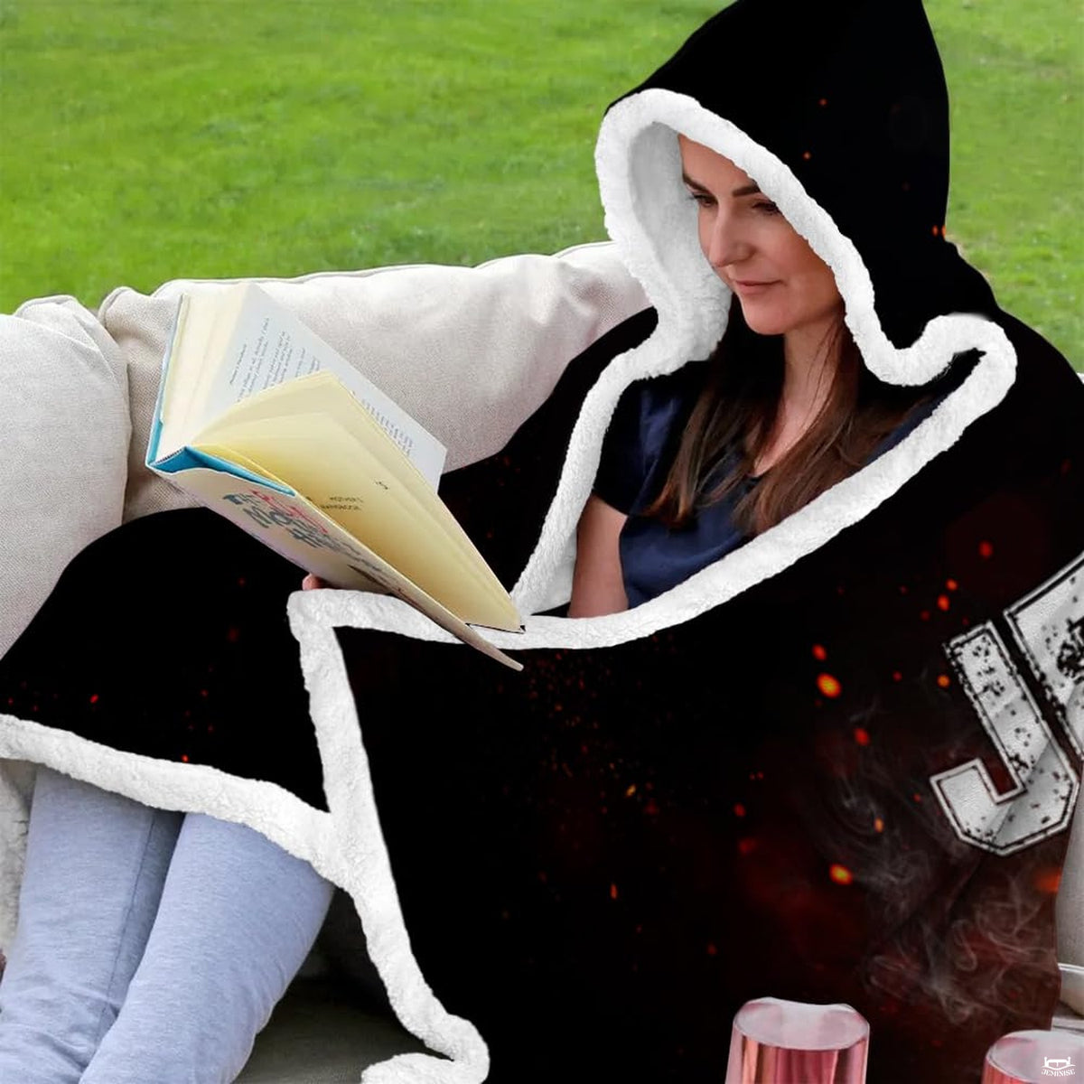 Lifestyle presentation of woman relaxing on an outdoor patio couch wrapped in black sports textile.