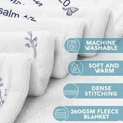 Lifestyle display of a person resting with the navy botanical faith throw blanket.