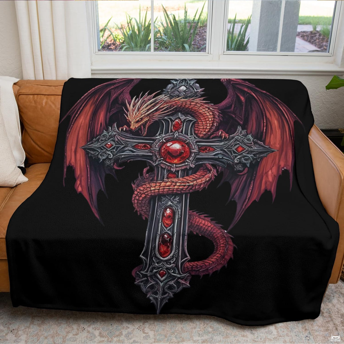 Gothic dragon cross throw blanket folded neatly on a dark accent chair.