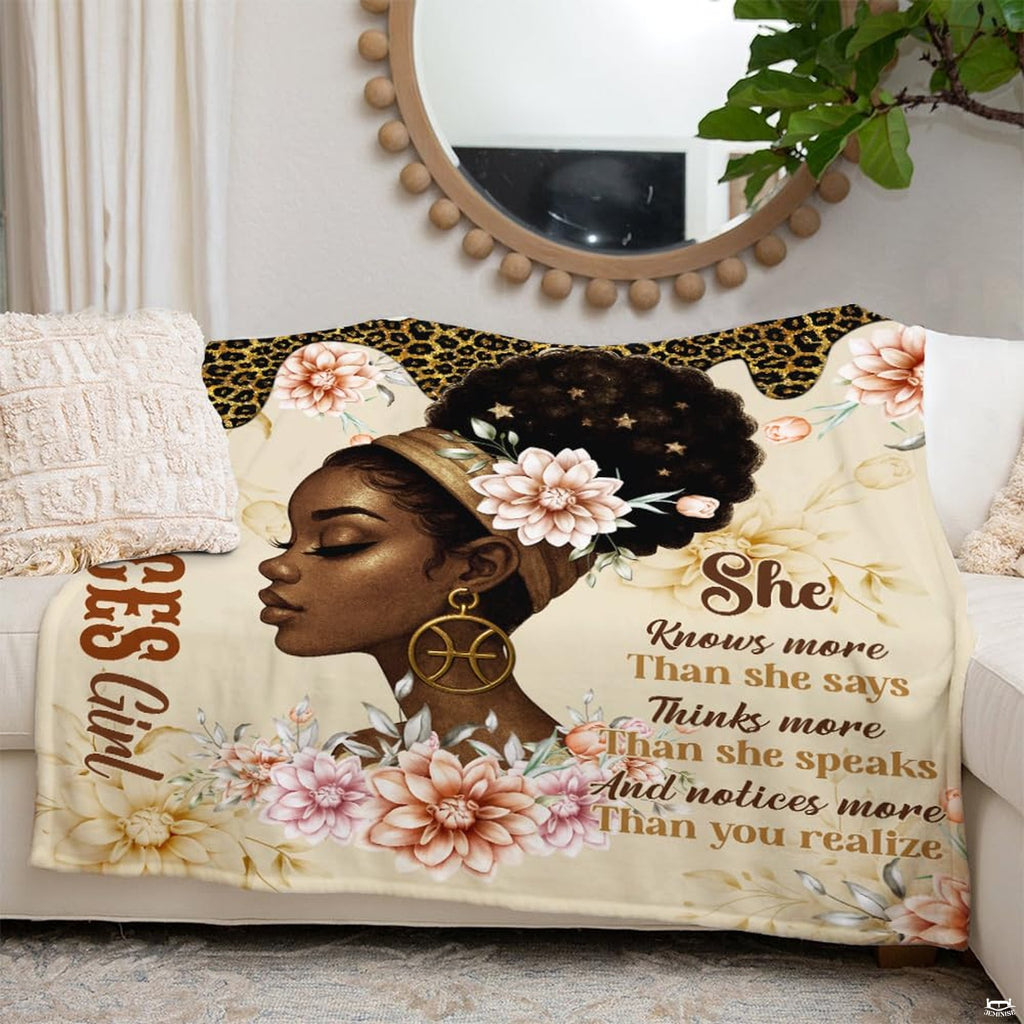 Astrology themed throw blanket draped across a living room couch.