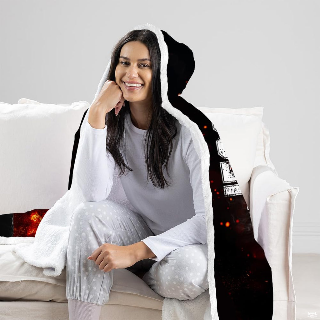 Woman sitting on a white living room couch wearing black athletic sports textile with flame ember graphic.