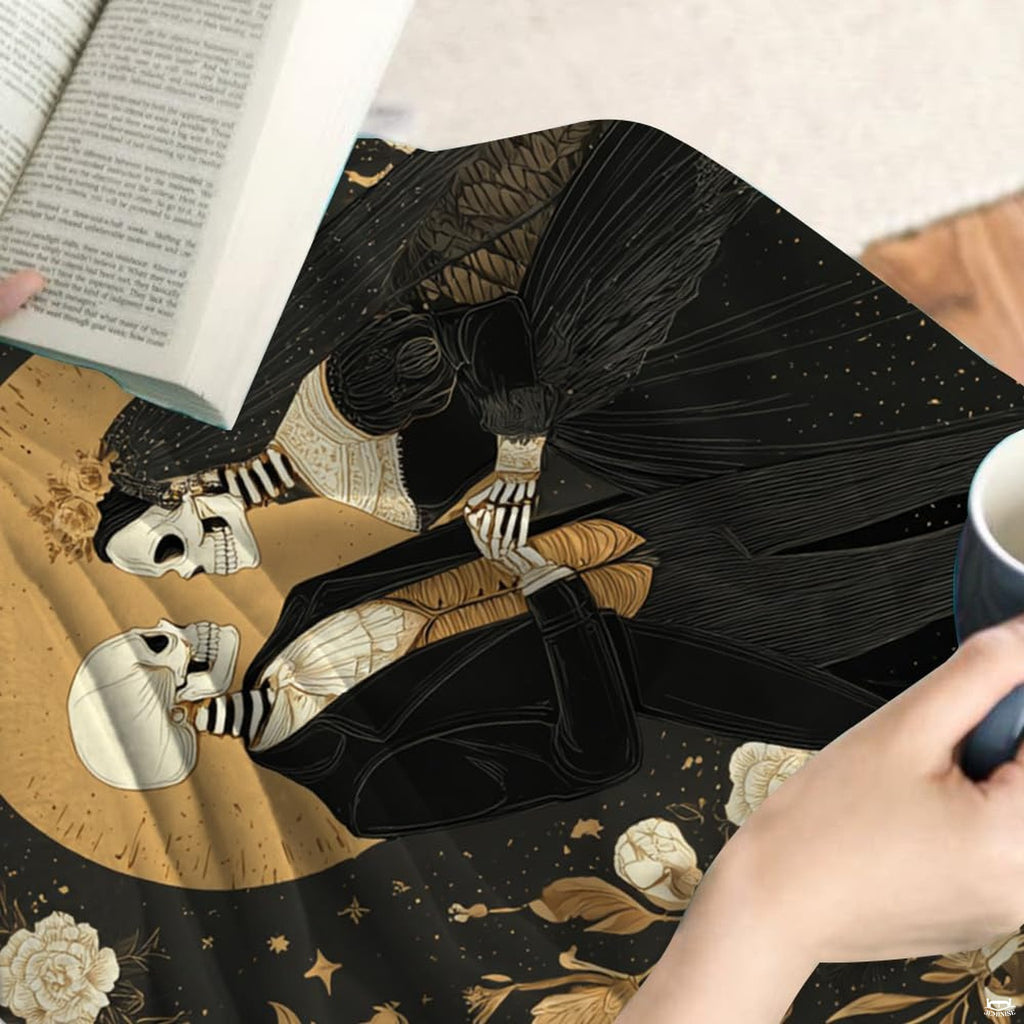 Close-up detail of skeleton bride lace dress and golden moon halo artwork on throw blanket