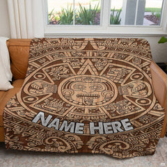 Carved timber sun stone calendar textile displayed across a brown couch in sunlit room.