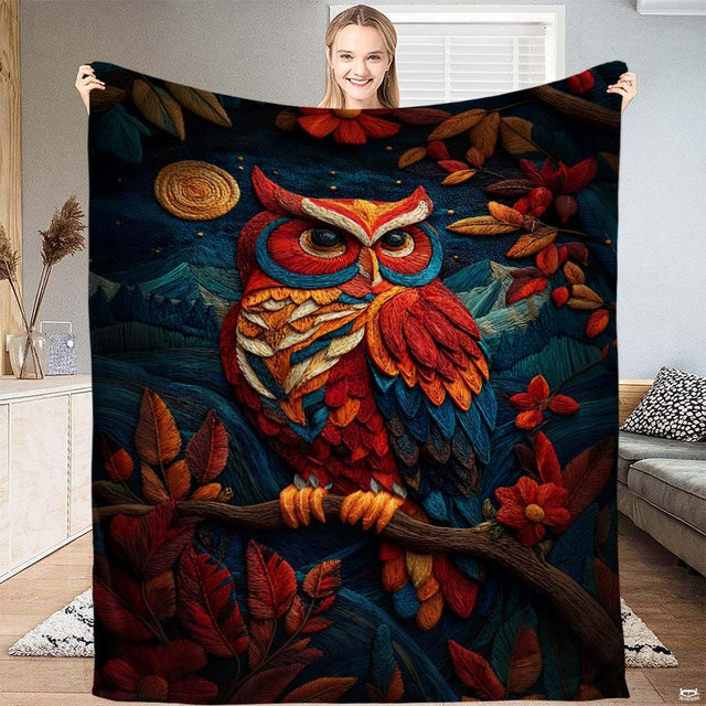 Colorful textured owl perched on a branch overlooking mountain peaks and autumn leaves on a throw blanket