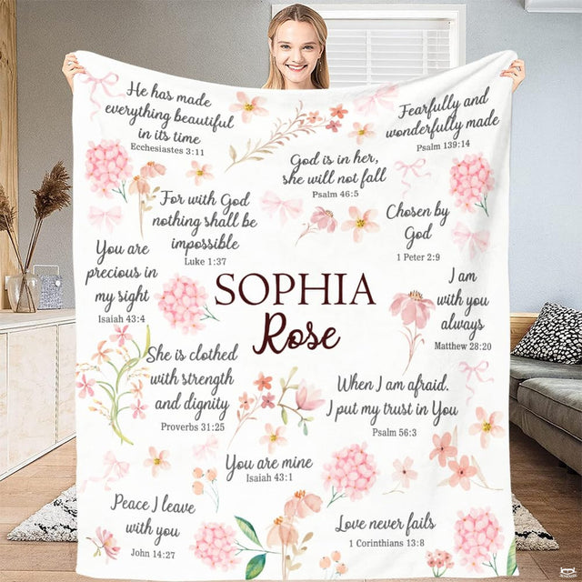 Full view of floral faith throw blanket held up, showing pink hydrangeas, ribbons, and scripture calligraphy.