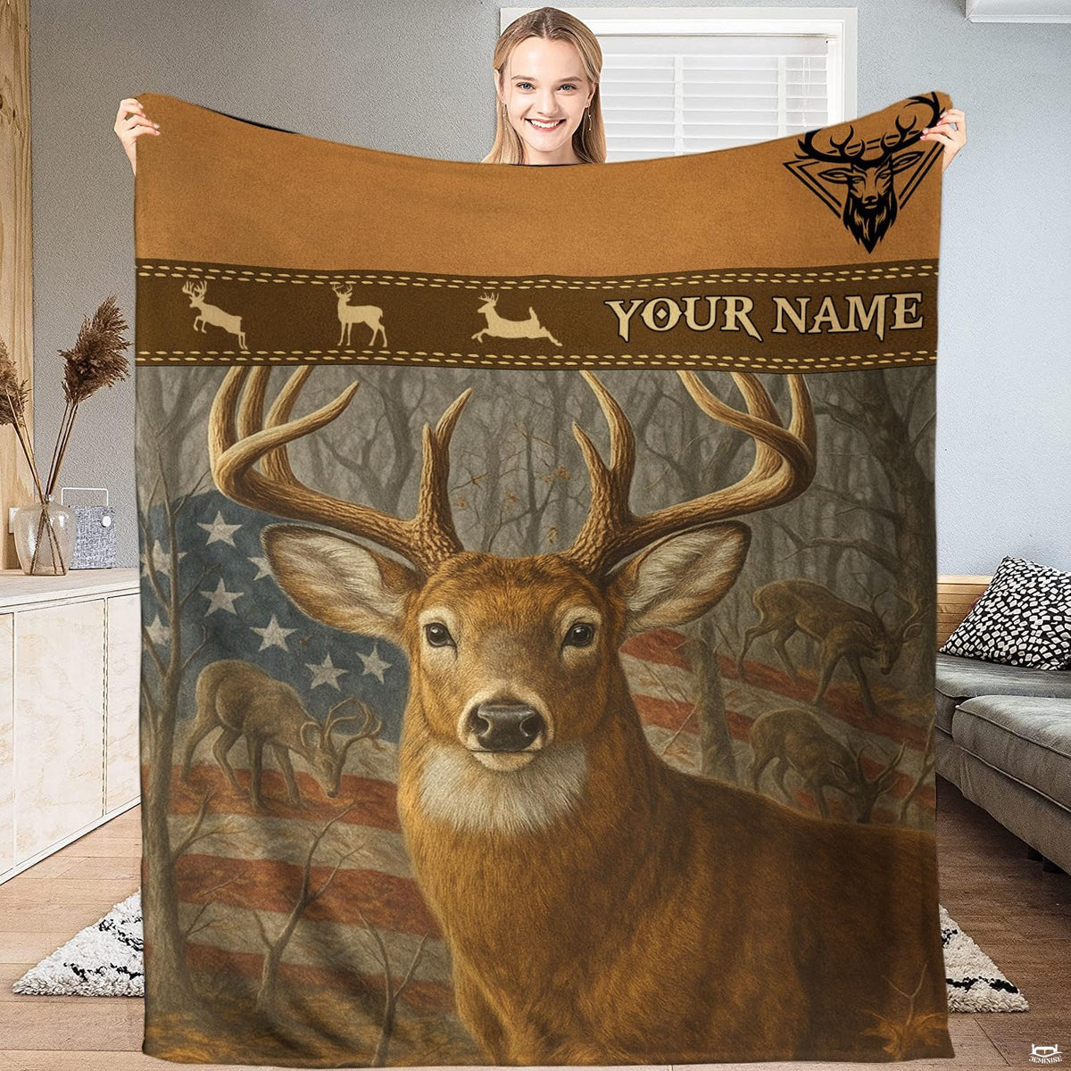 Model holding up an outdoor blanket displaying a whitetail buck before an American flag and woodland trees.