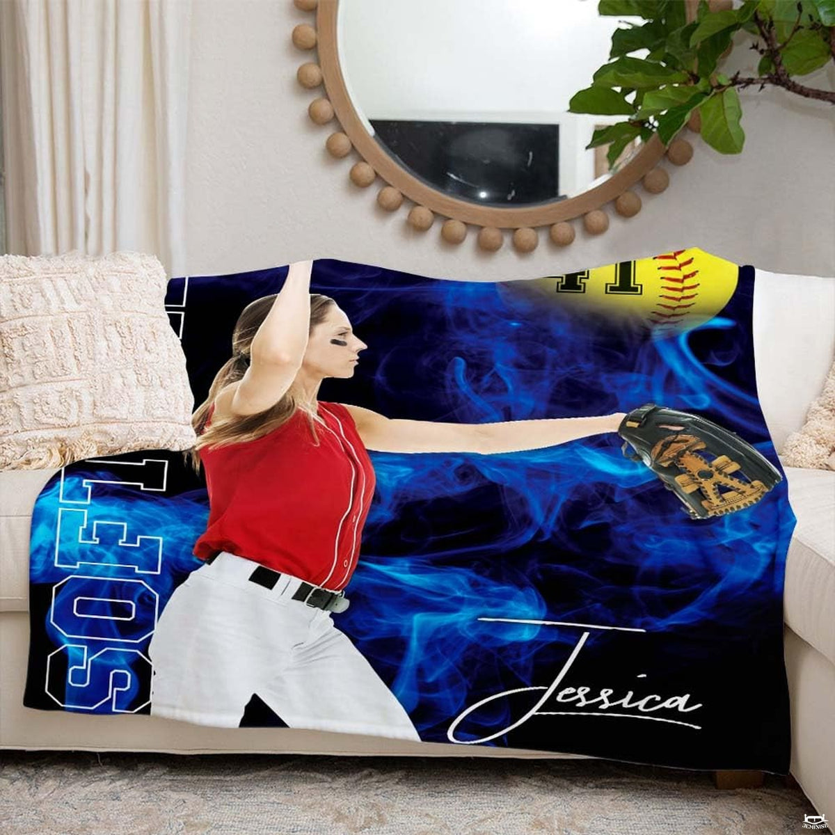 Blue smoke athletic pitcher graphic styled across a white couch beneath a circular mirror.