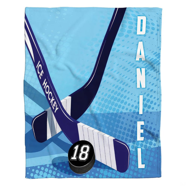 Hockey sticks and puck blanket showing crossed player sticks and black puck on cyan halftone ground.