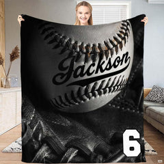 Monochrome studio still-life of a baseball inside a black fielder glove with dramatic lighting, view 2.