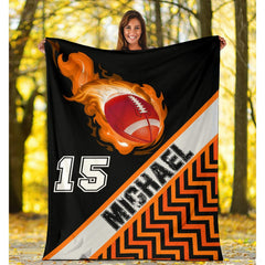 Folded athletic blanket highlighting orange zigzags and diagonal sash