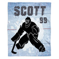 Hockey goalie silhouette blanket showing goaltender poised over ice rink markings and splatters.