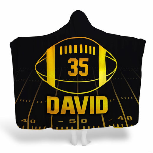 Black and gold football throw blanket featuring glowing golden football emblem and night yard lines