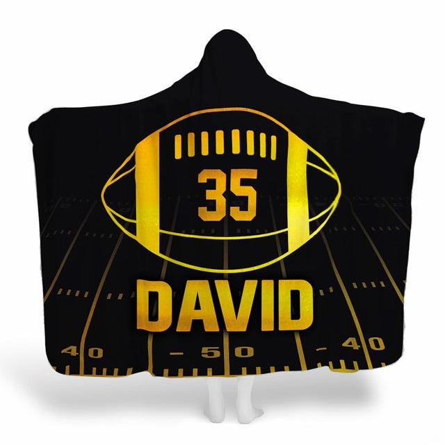 Black and gold football throw blanket featuring glowing golden football emblem and night yard lines