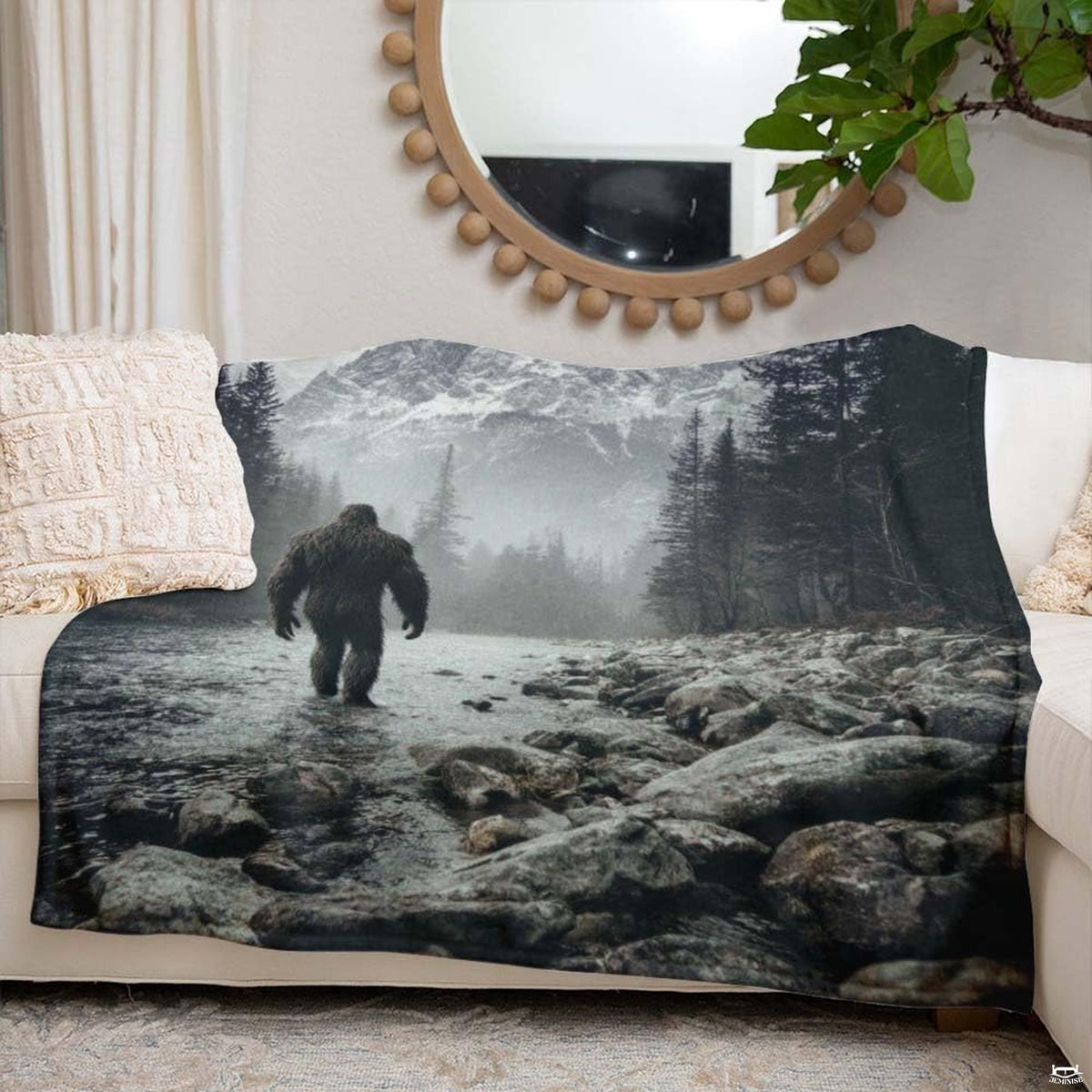 Bigfoot walking through a rocky mountain river toward snow-capped peaks, view 6.