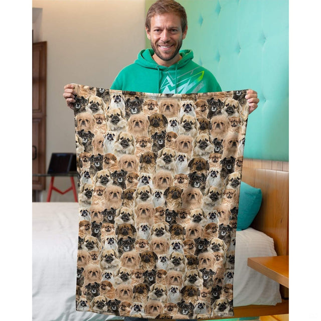 Model holding up a Pekingese dog collage blanket in an indoor bedroom setting.