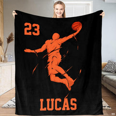 Dynamic orange basketball slam dunk artwork displayed across bedding set in a modern bedroom setting.