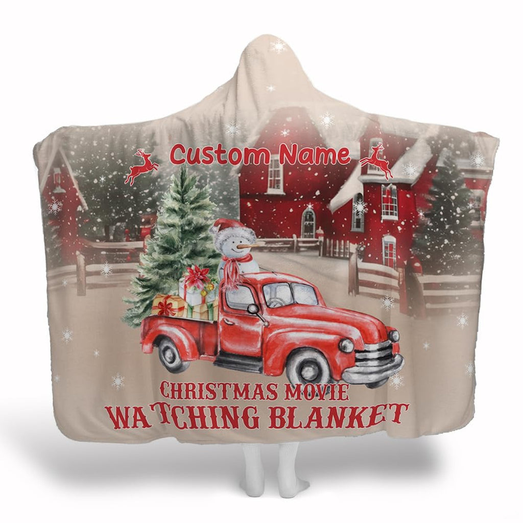 Vintage red truck laden with holiday gifts and a cheerful snowman parked in snowy farmland.