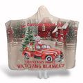 Vintage red truck laden with holiday gifts and a cheerful snowman parked in snowy farmland.
