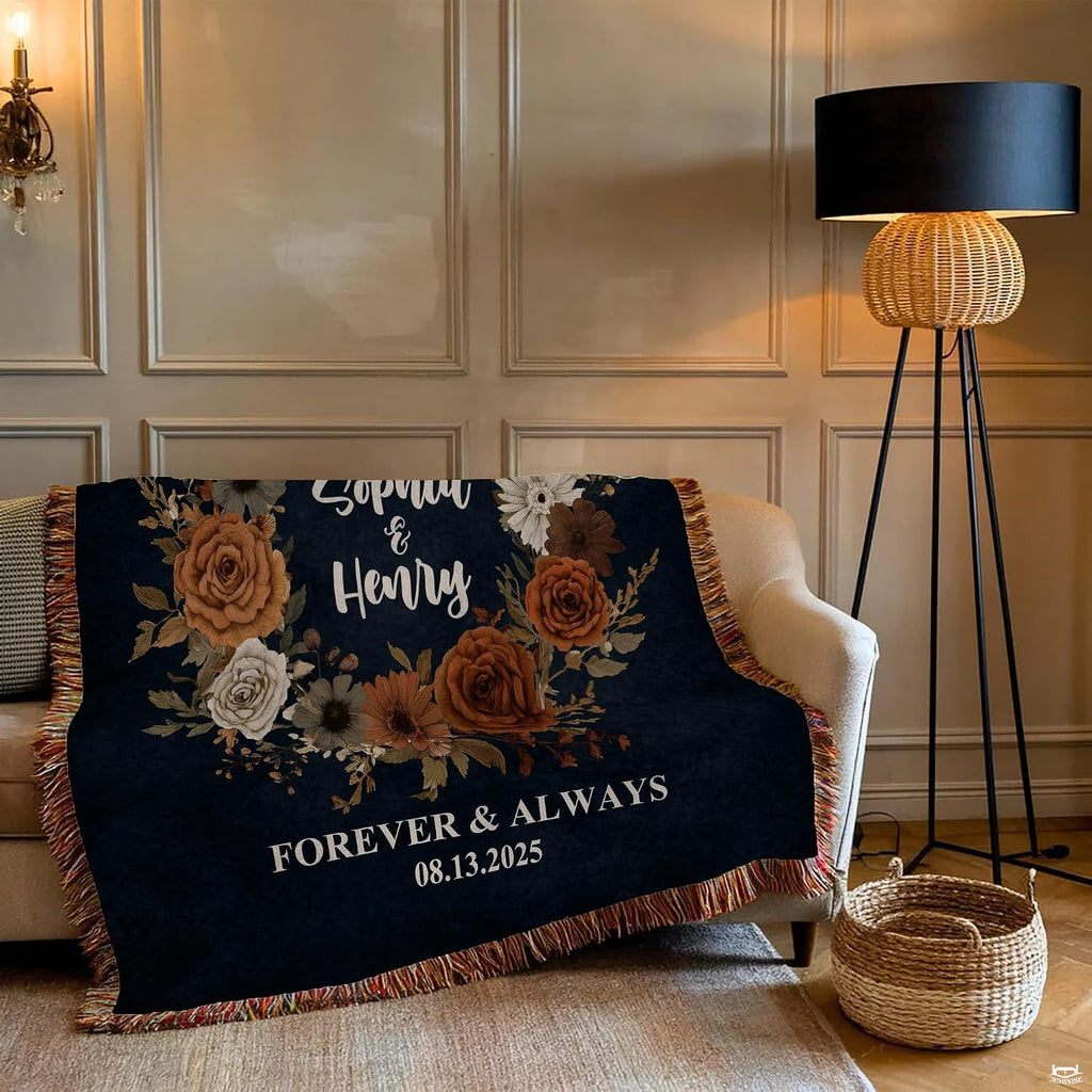 Close-up of terracotta roses, cream daisies, and dried botanical foliage on a dark navy blanket