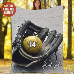Person holding up the black fastpitch mitt graphic in an autumn outdoor park setting.