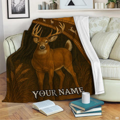 Woodland whitetail buck blanket draped across an indoor living room couch next to stacked books.