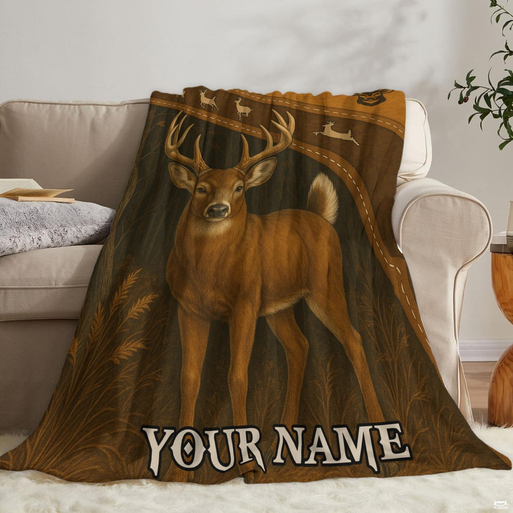 Rustic whitetail buck blanket draped neatly over a living room couch beside an accent pillow.