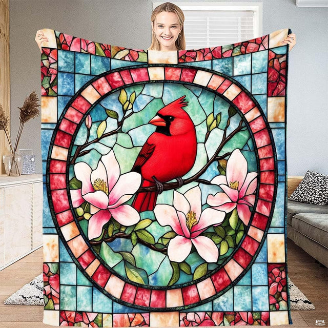 Stained glass red cardinal throw blanket featuring a bird among pink magnolia blossoms in a circular mosaic frame.
