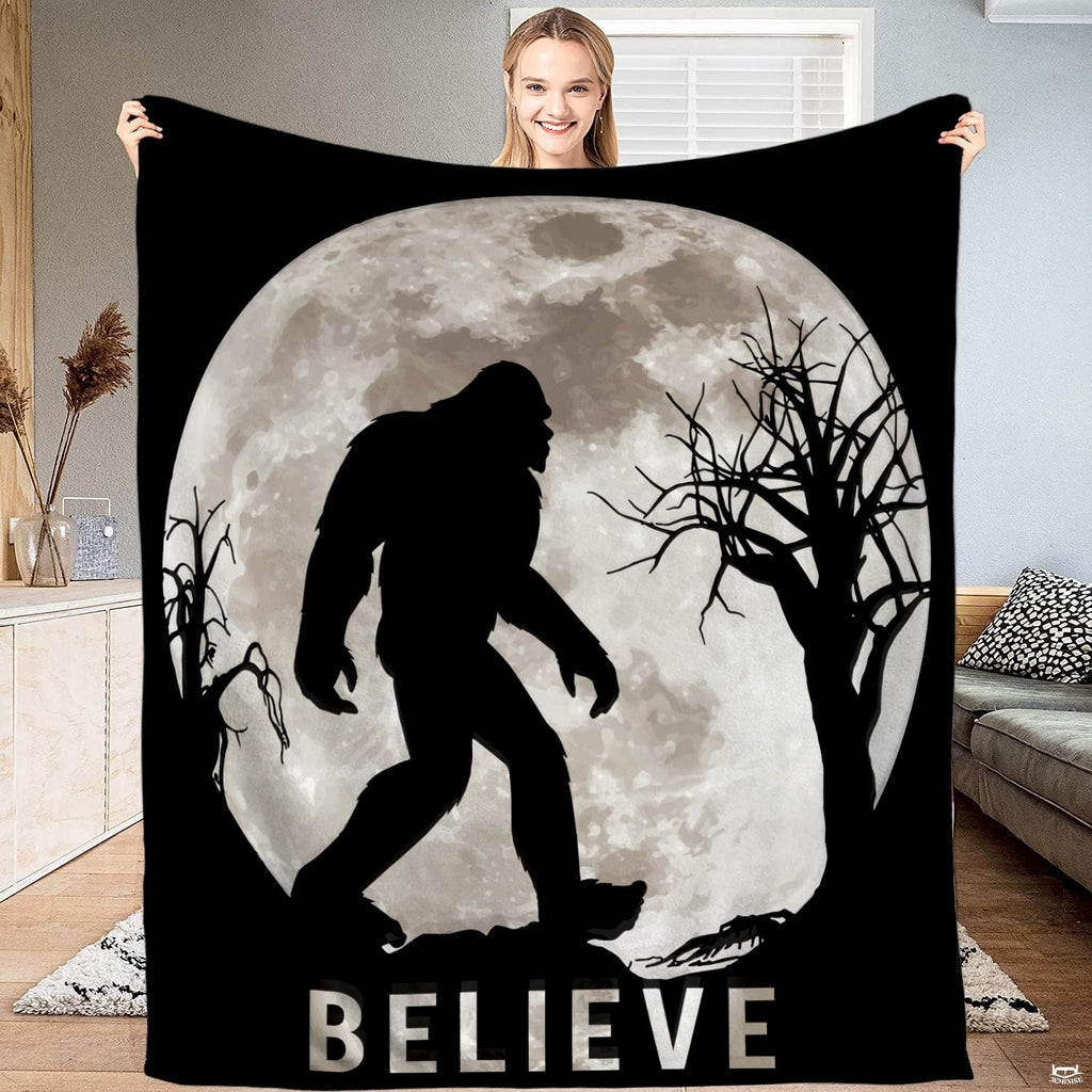 Bigfoot blanket held open displaying the full moon Sasquatch silhouette and night forest artwork.