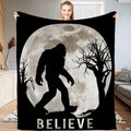 Bigfoot blanket held open displaying the full moon Sasquatch silhouette and night forest artwork.