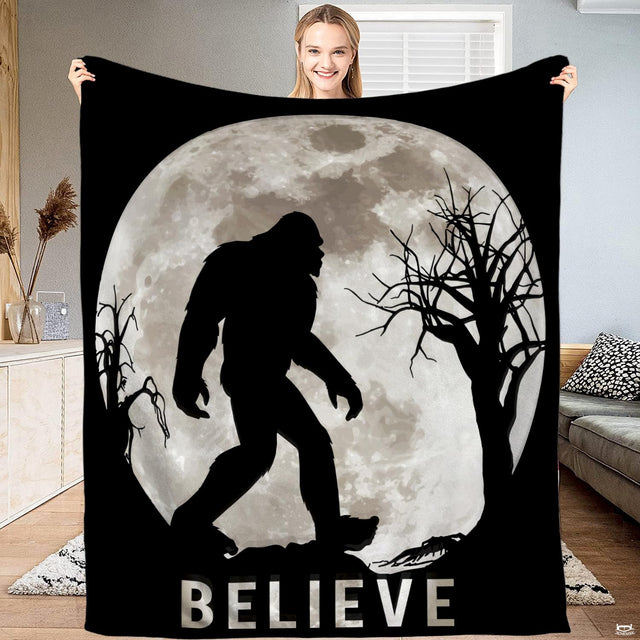 Bigfoot blanket held open displaying the full moon Sasquatch silhouette and night forest artwork.