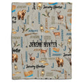 Rustic throw blanket with illustrated bears, deer, mallards, and outdoor gear pattern on beige