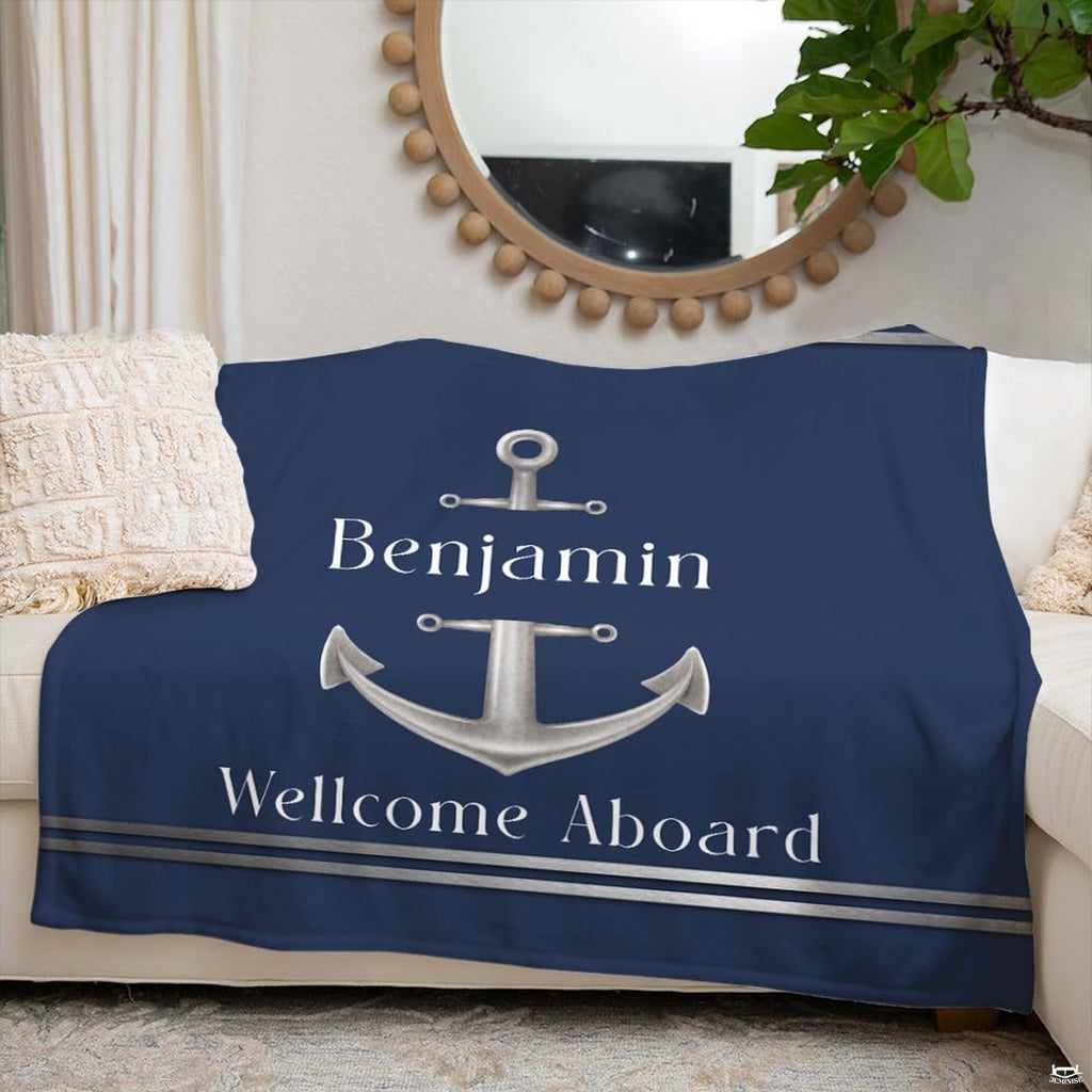 Silver anchor nautical print styled across a couch beneath a round decorative mirror.