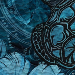 Close-up view of turtle bedding showcasing intricate Polynesian tribal motifs and ocean cyan tones