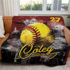 Softball throw blanket arranged neatly across brown leather living room sofa
