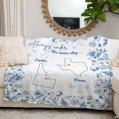 Angle perspective of blue botanical state map throw blanket styled across contemporary sofa