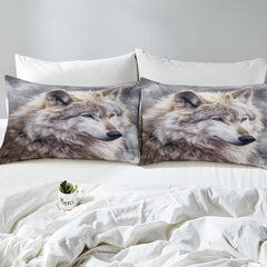 Close view of matching pillows with pale wolf portraits on misty gray