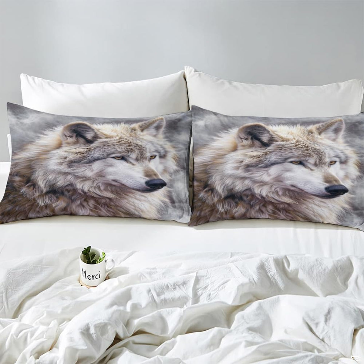 Close view of matching pillows with pale wolf portraits on misty gray