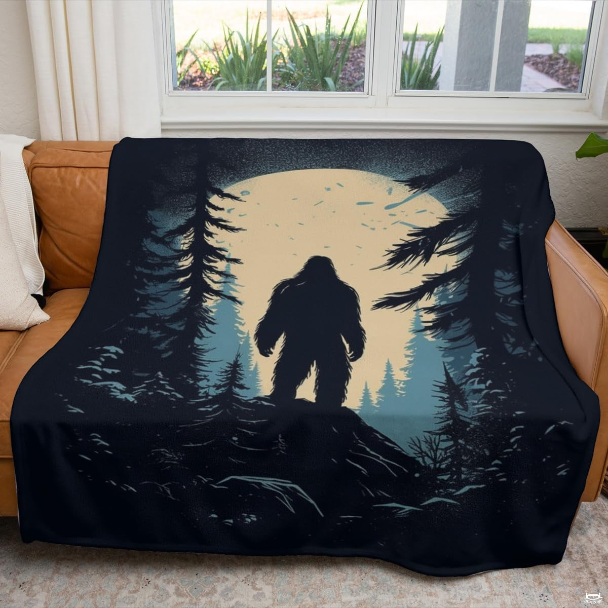Nocturnal Bigfoot mountain blanket styled across a living room couch.