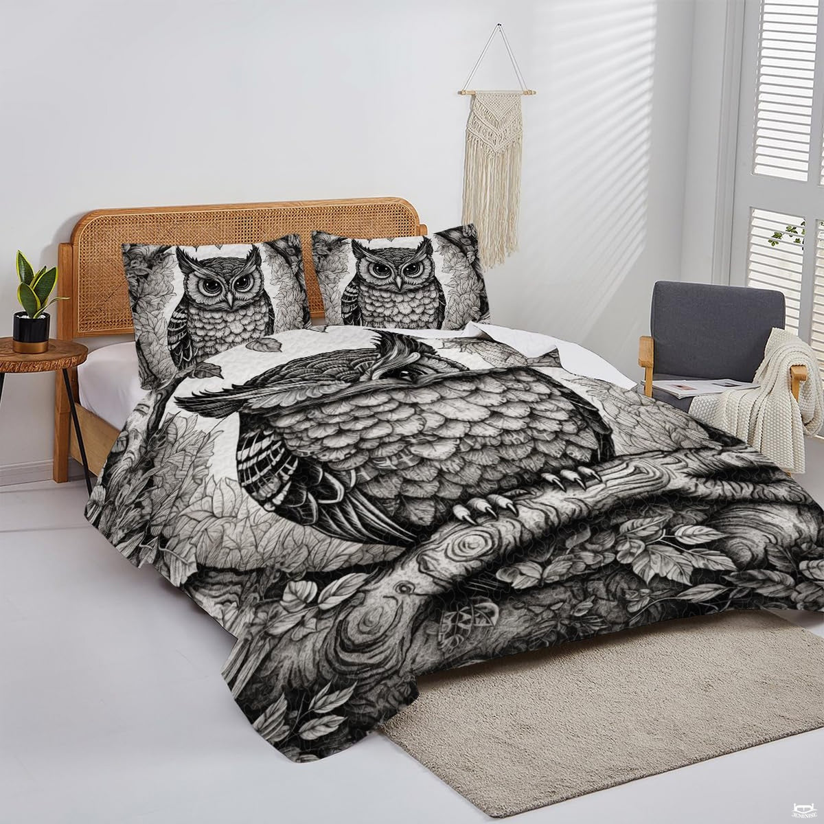 Overhead perspective of owl bedding arranged neatly across a mattress with neutral room decor