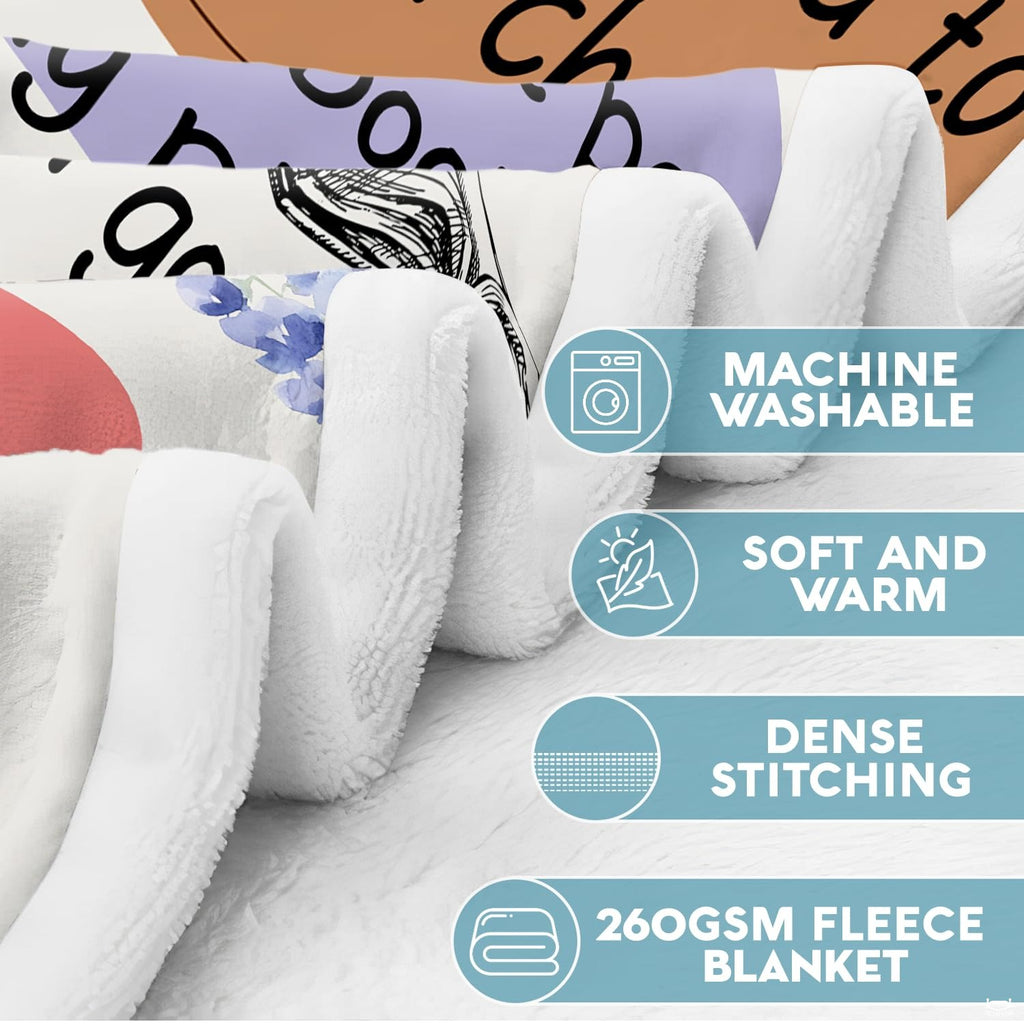 Close-up view of bookish sayings throw blanket highlighting pastel quote shapes and delicate botanical art.