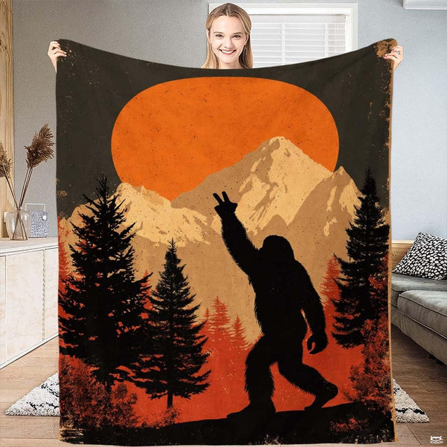 Bigfoot peace sign mountain sunset blanket featuring Sasquatch silhouette in pine forest.