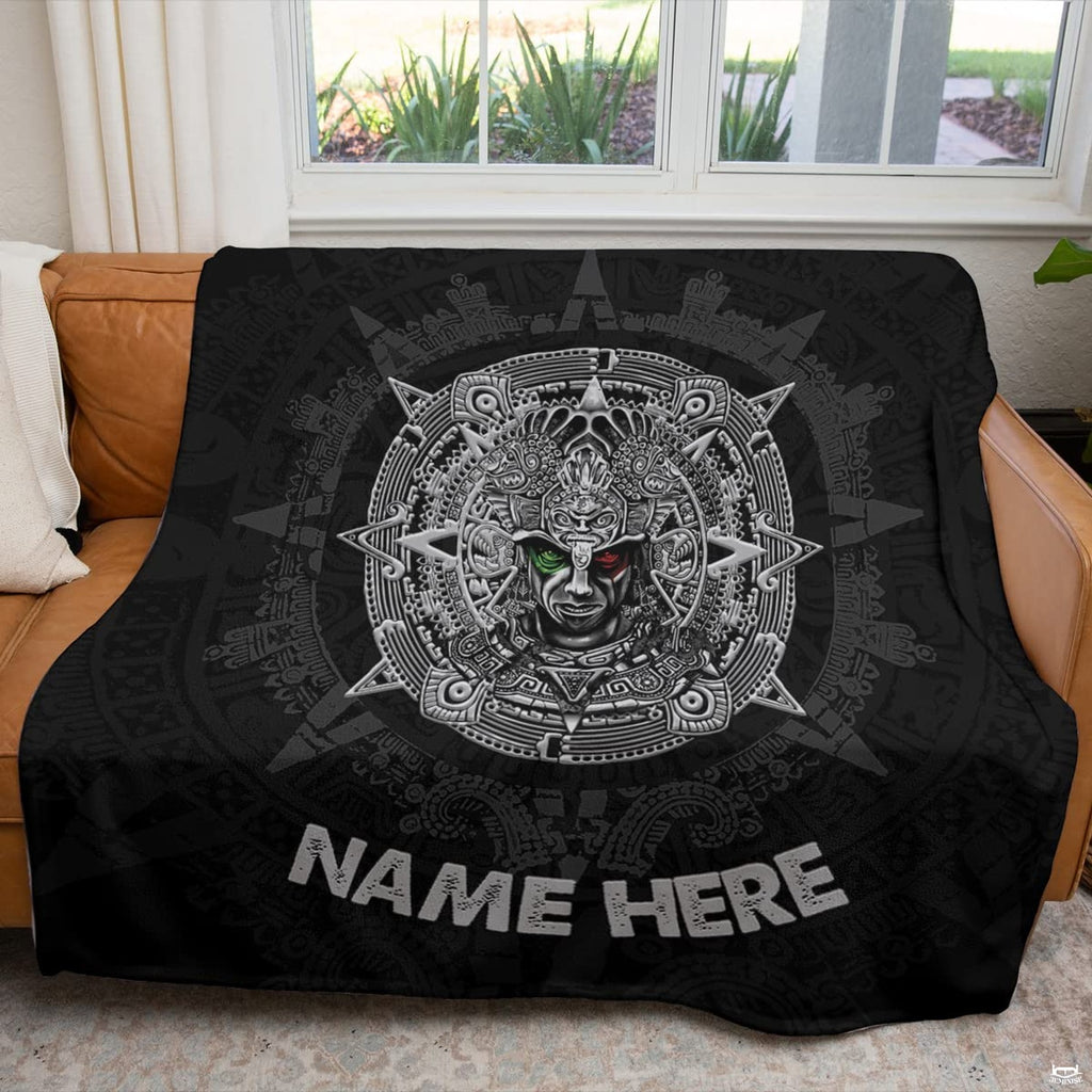 Aztec sun stone calendar textile displayed across a brown couch in sunlit living room.